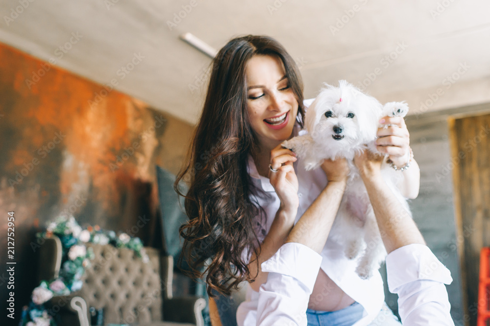 Portrait of cheerful married and pregnant couple with a dog lying on bed in the morning. Portrait of cheerful married and pregnant couple with a dog lying on bed in the morning.