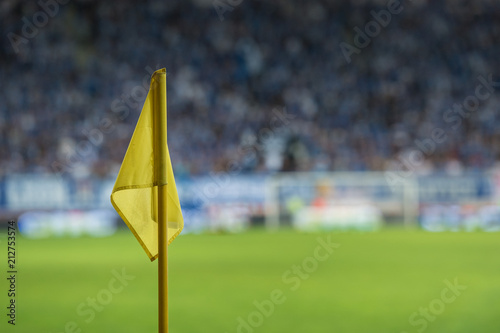 Corner flag at the football pitch, in the background audience.