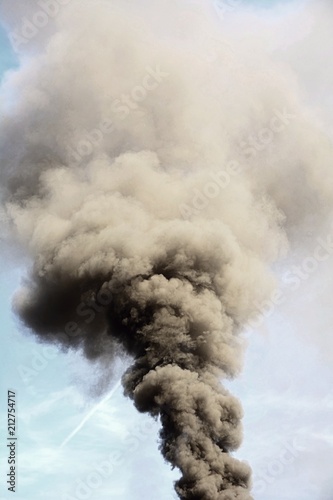 Environmental disaster and air pollution by big smoke column from chimney.
