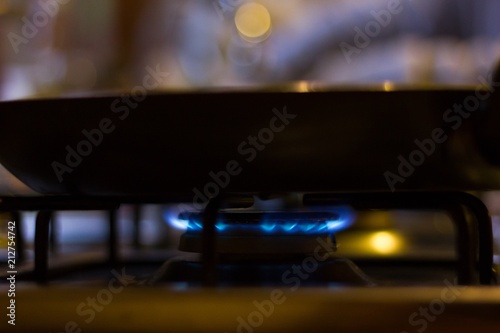 Fry pan on gas cooking stove with blue fire. Danger, hot concepts