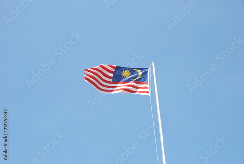 Malaysian flag waving in the wind with clear blue sky