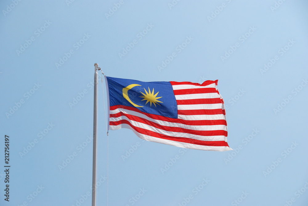 Malaysian flag waving in the wind with clear blue sky