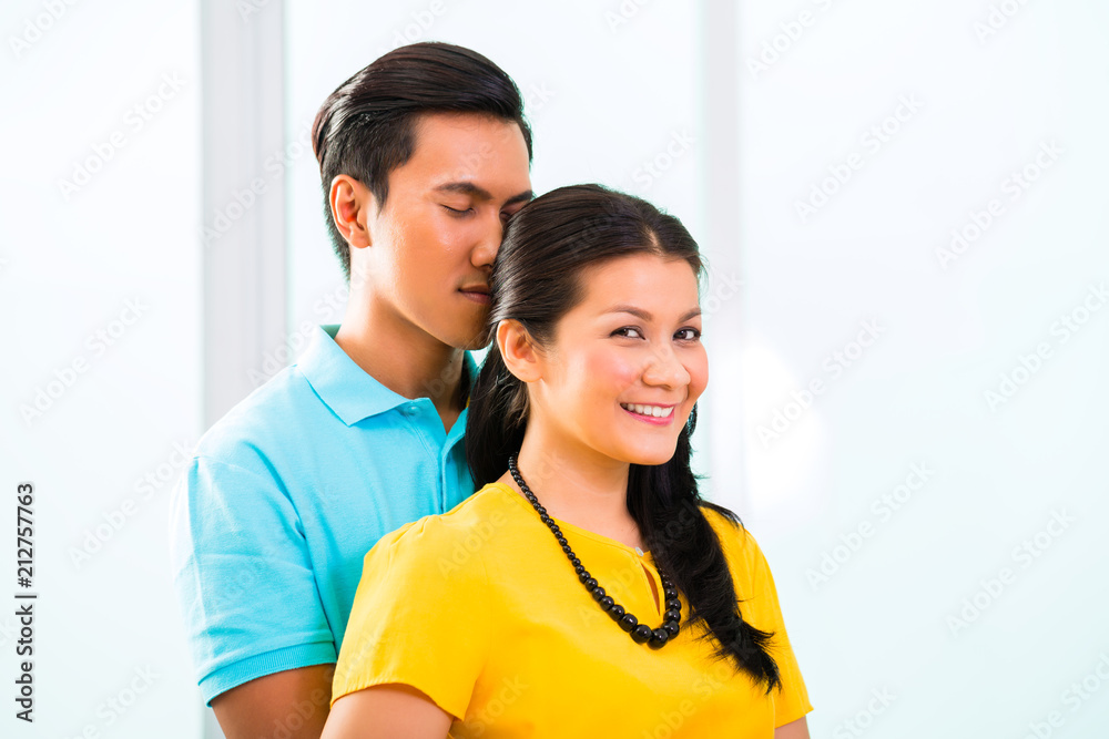 Young Asian handsome couple in apartment having long-term relationship cuddling together Young Asian handsome couple in apartment having long-term relationship cuddling together