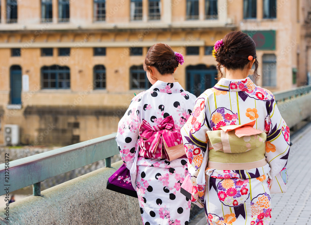 Two girls in a kimono on a city street, Kyoto, Japan. Back view.