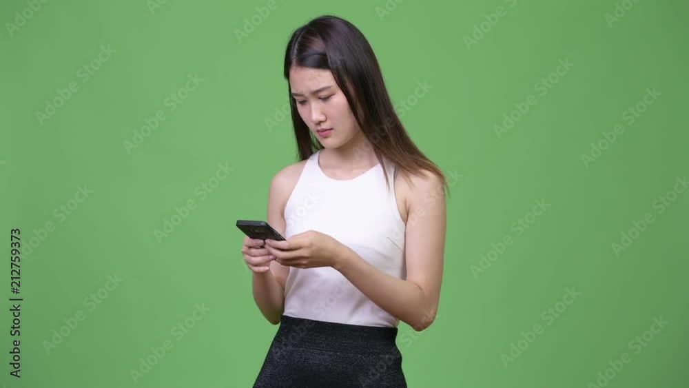 Young beautiful Asian businesswoman using phone