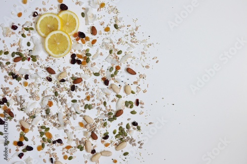 Lemon slices  seeds and cereals on the left of the white table  top view  flat lay  copy space