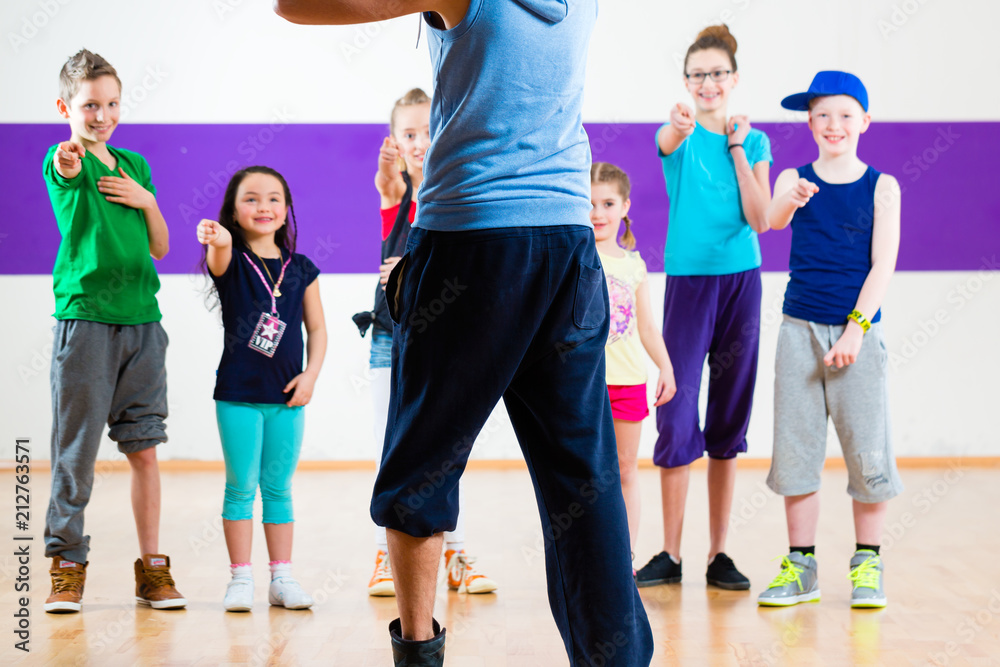Fototapeta premium Dance teacher giving children fitness class in gym