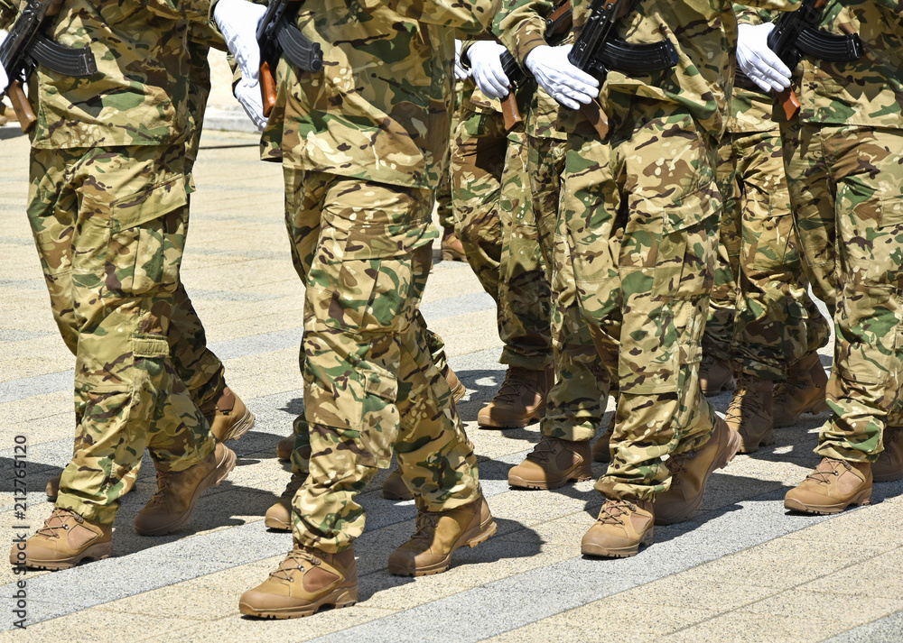 Soldiers marching with machine guns in hand Soldiers marching with machine guns in hand