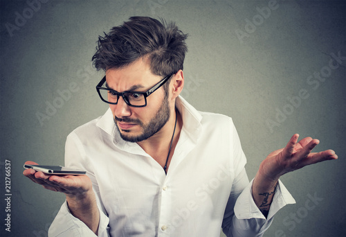 Man with smartphone in misunderstanding