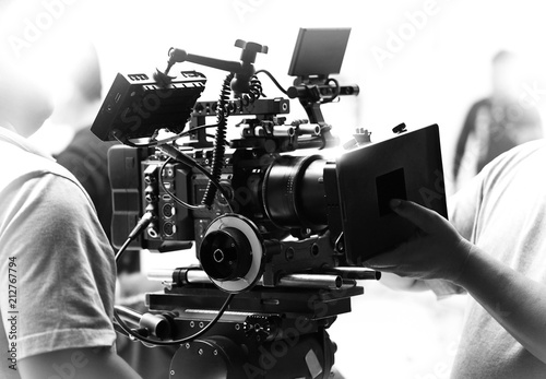 Movie shooting or video filming production by crew team and professional equipment such as super ultra high definition digital camera with tripod and lighting set in studio and black and white styles. photo