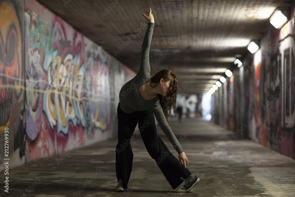 Obraz premium Female Dancer in Motion Dancing in an Urban Underpass