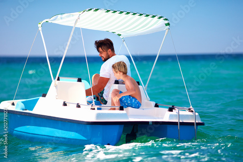 happy family, father and son enjoy sea adventure on watercraft catamaran at summer vacation © Olesia Bilkei