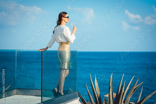 Woman enjoying glass of champagne at the sea
