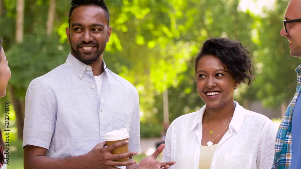 people, friendship and international concept - group of happy friends drinking coffee and talking in summer park people, friendship and international concept - group of happy friends drinking coffee and talking in summer park