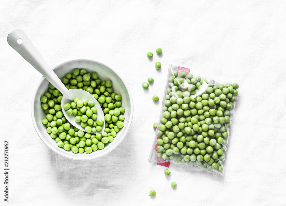 Fresh and frozen green peas on a light background, top view. Concept of homemade preparations for cooking. Healthy vegetarian food concept - obrazy, fototapety, plakaty 