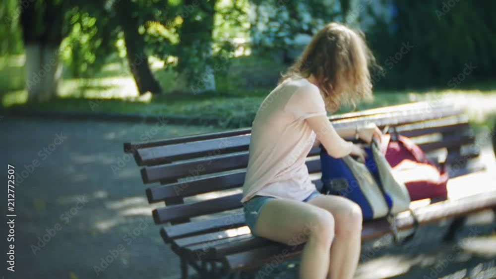 woman dresses roller skates sitting on bench in park woman dresses roller skates sitting on bench in park