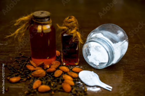 Fotografie Close up of sea salt, almond oil and clove for alleviation from headache on wooden surface ayurvedic home remedy