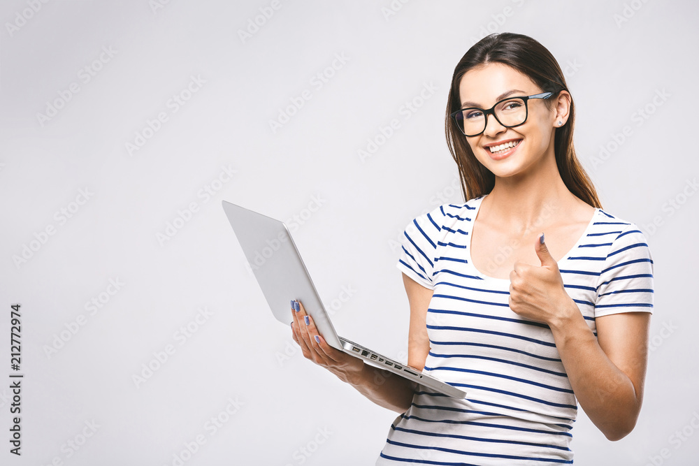 Portrait of happy young beautiful smiling woman standing with laptop isolated on white background. Space for text. Portrait of happy young beautiful smiling woman standing with laptop isolated on white background. Space for text.