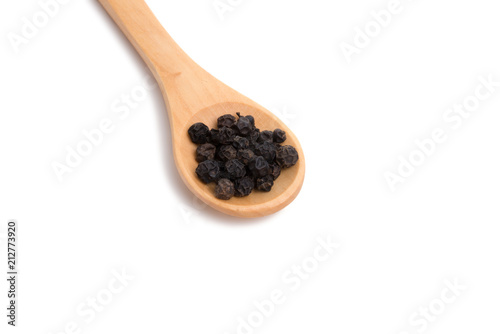 black dried pepper in wooden spoon isolated on the white