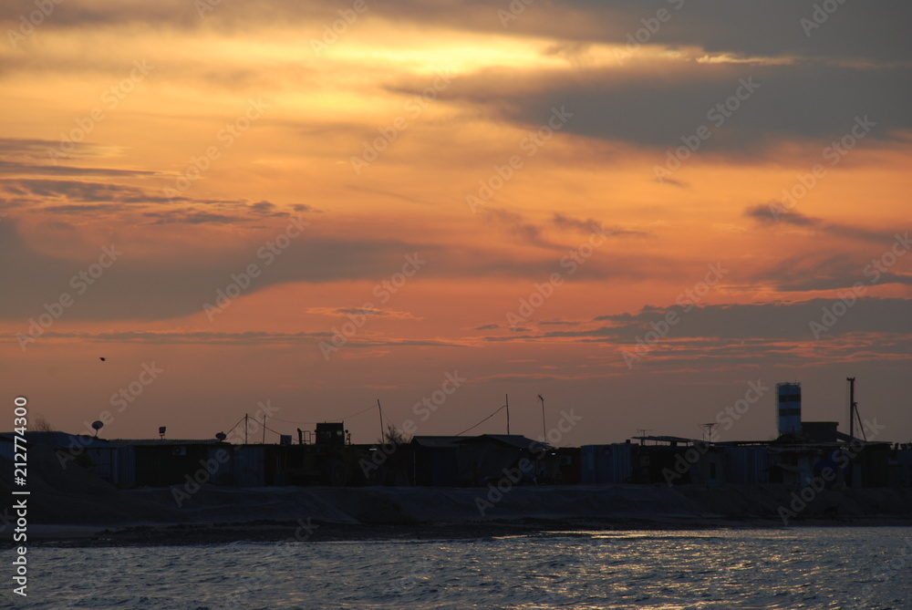 Sunset over industrial area and sea