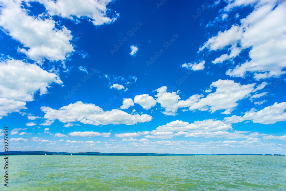 Summer green water lake with cloudy blue sky