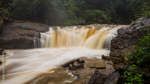 Waterfall after recent rains , long shutter with wet rock foreground