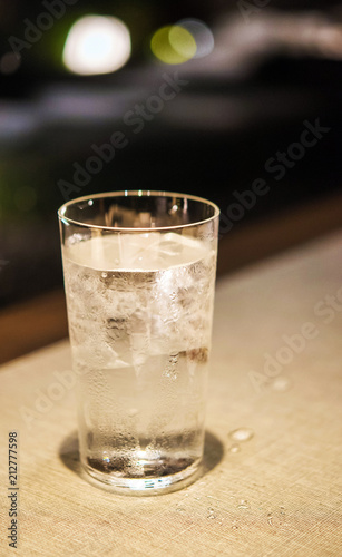 A glass of cold water on a table, Tokyo, Japan. Vertical.