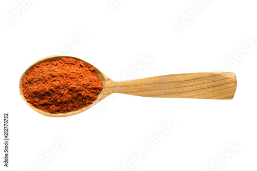 chili powder in wooden spoon isolated on white background. spice for cooking food, top view.