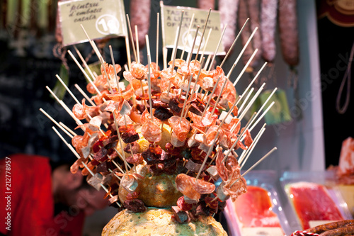 Assortment of Spanish meat sausages salchichon fuet chorizo on stick for sale at the Boqueria market in Barcelona