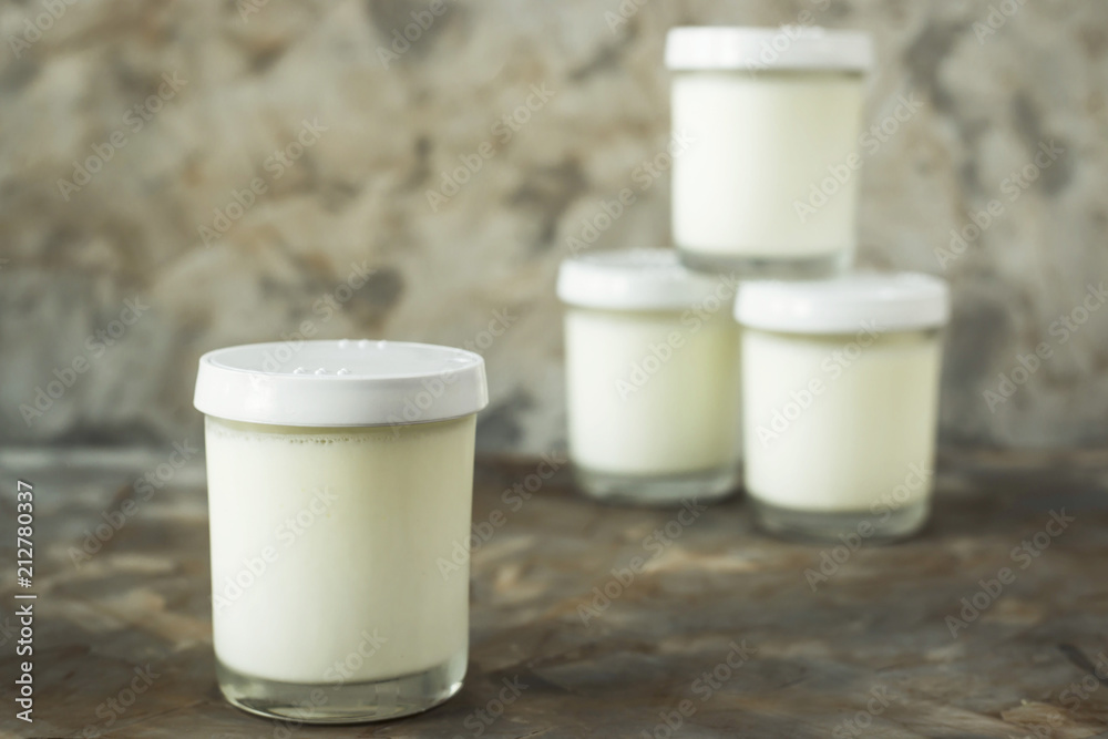 Four jars of homemade yogurt on a gray background. Dietary food Four jars of homemade yogurt on a gray background. Dietary food