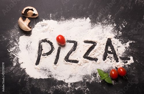 Photo Pizza concept. Lettering. Word Pizza on flour. Top view.