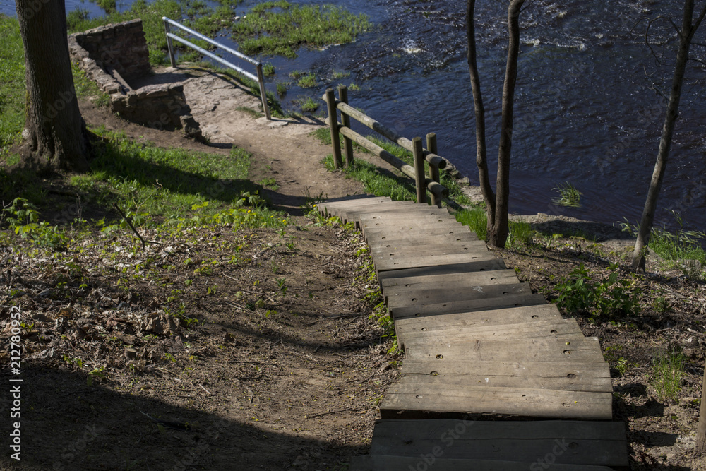 a long staircase in the park leads down and below the fast river