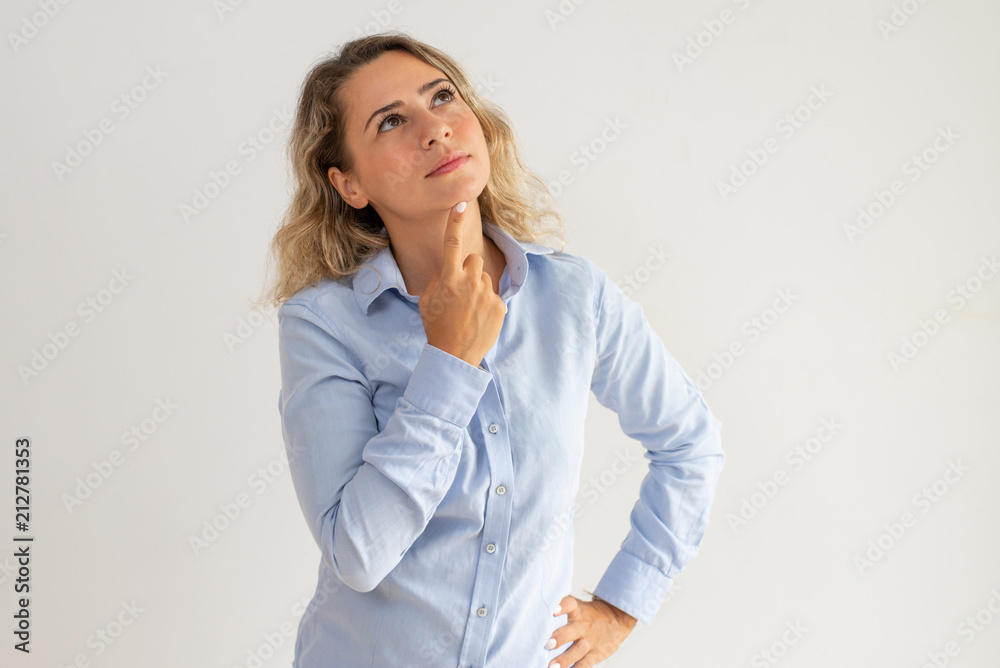 Portrait of pensive young Caucasian woman looking up. Businesswoman standing with thoughtful expression. Planning concept Portrait of pensive young Caucasian woman looking up. Businesswoman standing with thoughtful expression. Planning concept