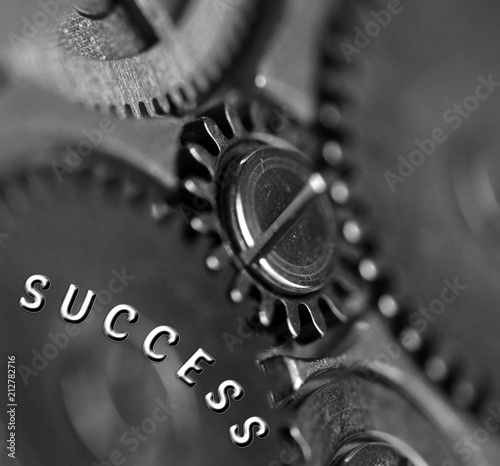 Background with the inscription Success. Black white background with metal cogwheels clockwork. Macro. Conceptual photo for your successful business design. Metallic black and white letters, gears. 