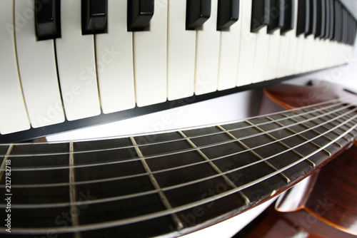 the piano keys and classical guitar close up on white background