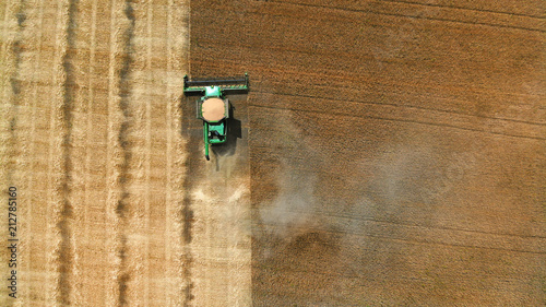 Aerial. Harvester harvests in the field.