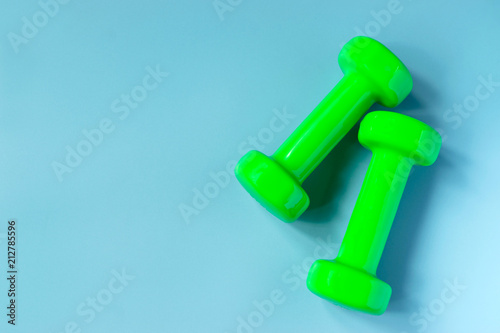 Top view dumbbells with measuring for diet or sport exercise concept on blue background.