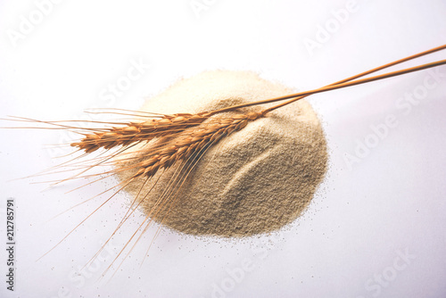 Raw unprepared semolina flour also known as Rava powder over white or moody background. selective focus