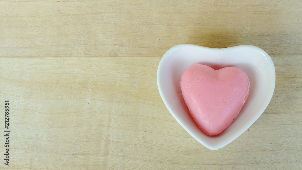 Obraz premium Heart soap in blow heart shaped on wooden table backgrounds above. Top views