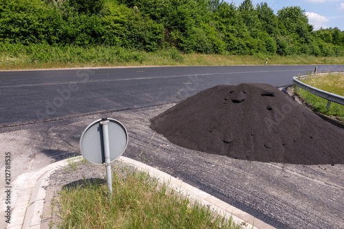 Großer Haufen loser Asphalt an einer frisch sanierten Straße photo