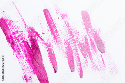 Nail polish on a white background in the form of strips and drops