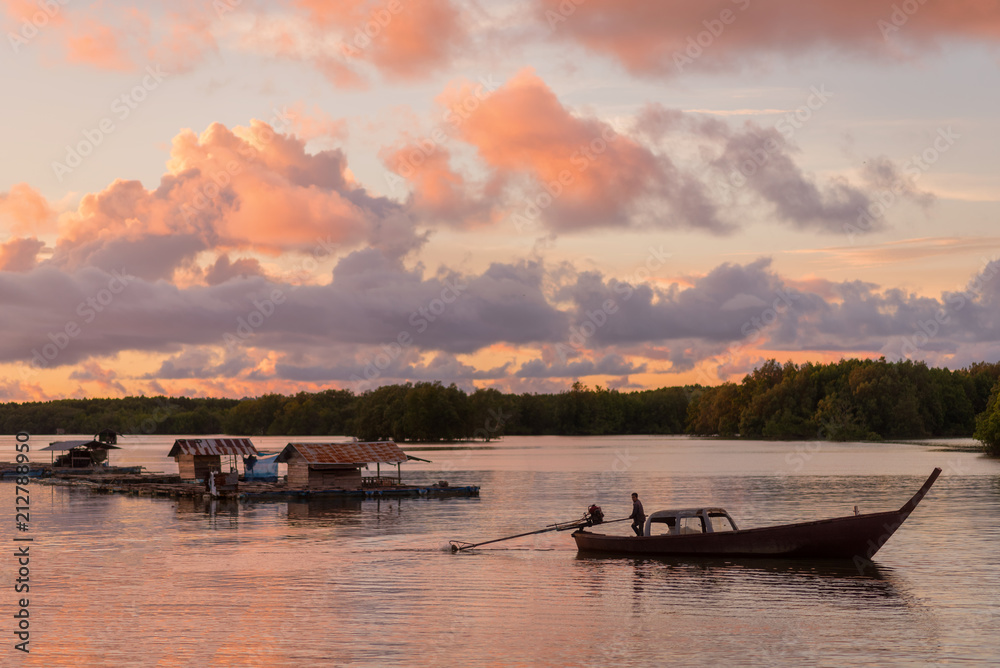 Sunset time, Fisherman on Long tail Boat In the mangrove canal and Houseboat , Ranong Thailand