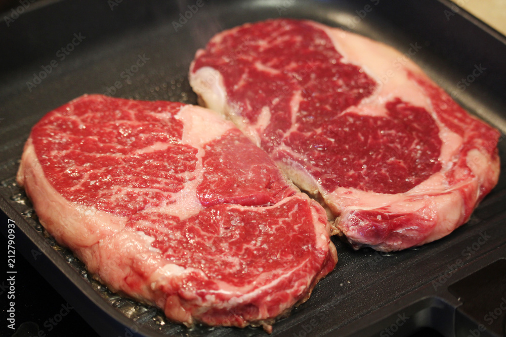 Raw steaks cooked on the pan