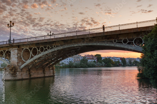 setting sun over the historic Puente de Triana bridge in Sevilla, Spain