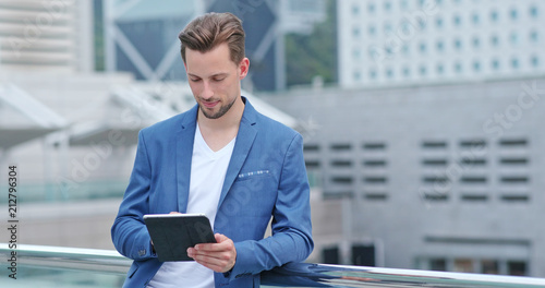 Photography Young businessman work on tablet computer at outdoor