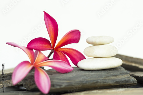 White spa stone with frangipani flowers on the slate floor. The concept of balance and harmony