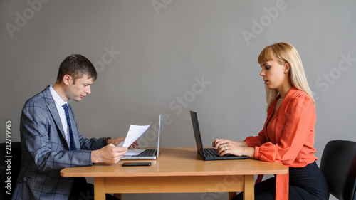 Bilde på lerret A business woman and man at the office desk, face to face