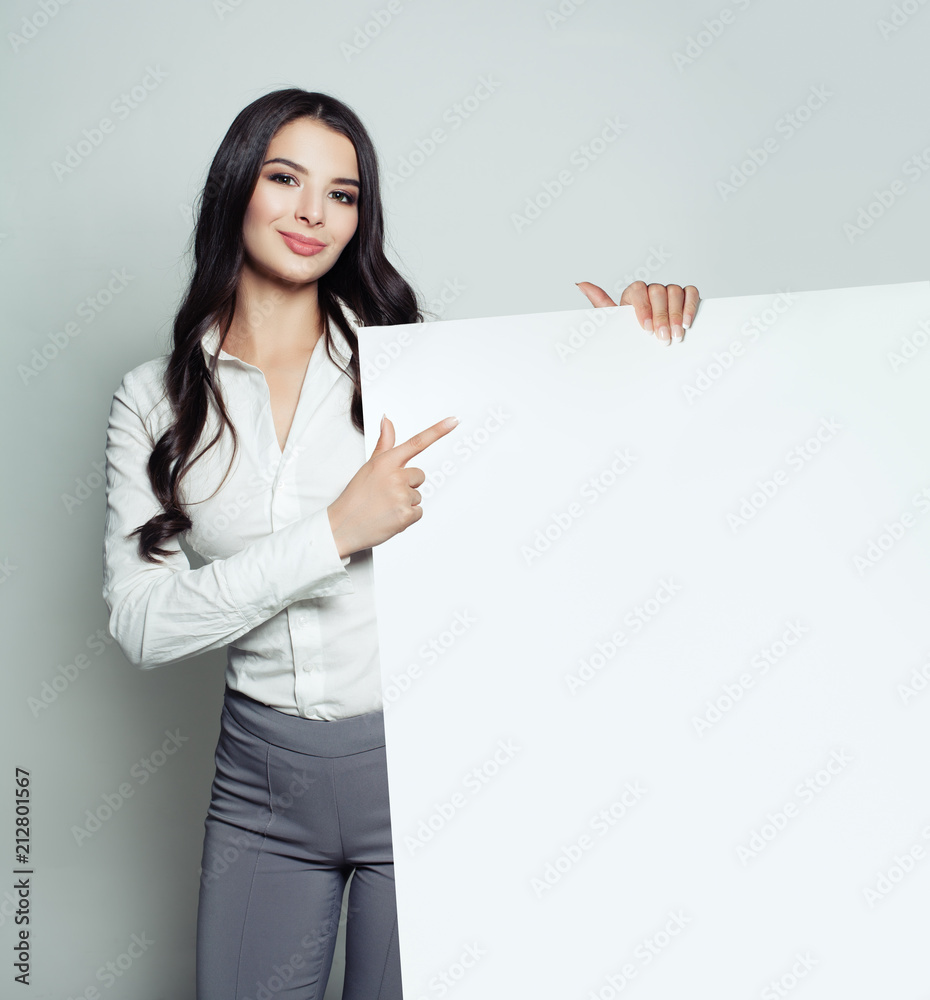 Business woman with white blank paper banner background. Young woman smiling, facecloseup, business and education concept Business woman with white blank paper banner background. Young woman smiling, facecloseup, business and education concept