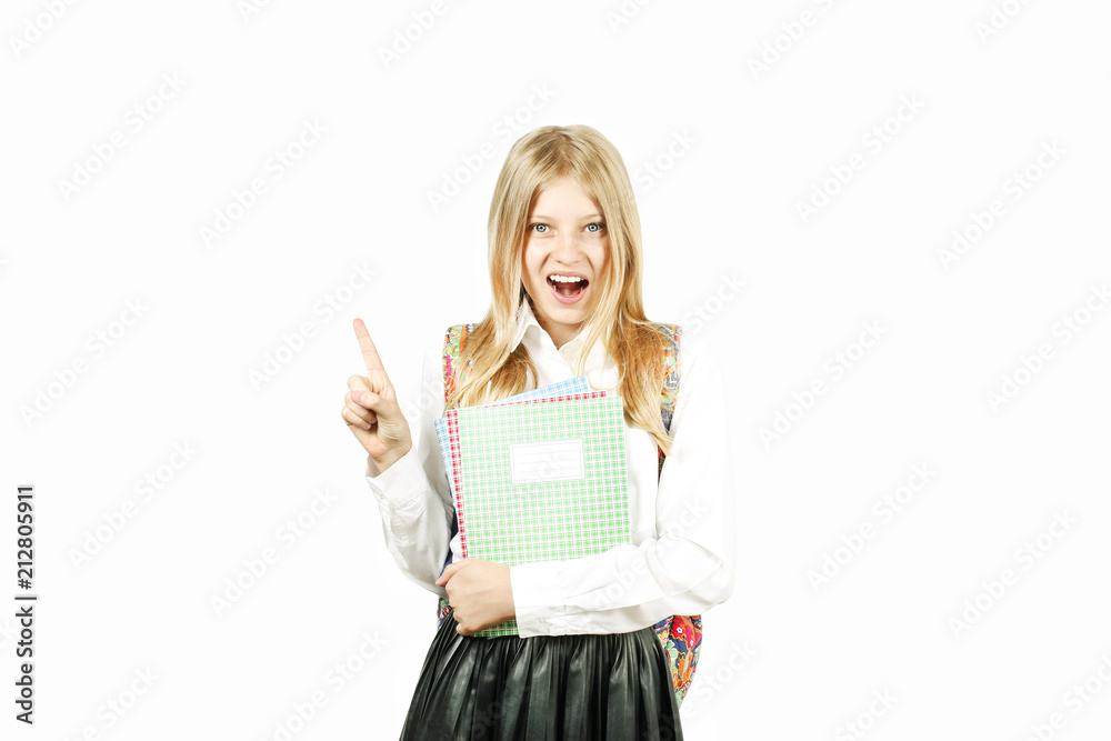 Close up portrait of young beautiful happy teenage school girl smiling wide, perfect teeth, standing on white background looking pointing up with index finger. Back to school sale concept. Copy space. Close up portrait of young beautiful happy teenage school girl smiling wide, perfect teeth, standing on white background looking pointing up with index finger. Back to school sale concept. Copy space.