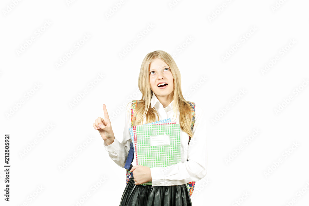 Close up portrait of young beautiful happy teenage school girl smiling wide, perfect teeth, standing on white background looking pointing up with index finger. Back to school sale concept. Copy space. Close up portrait of young beautiful happy teenage school girl smiling wide, perfect teeth, standing on white background looking pointing up with index finger. Back to school sale concept. Copy space.